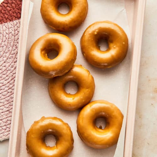 A tray filled with glazed donuts.