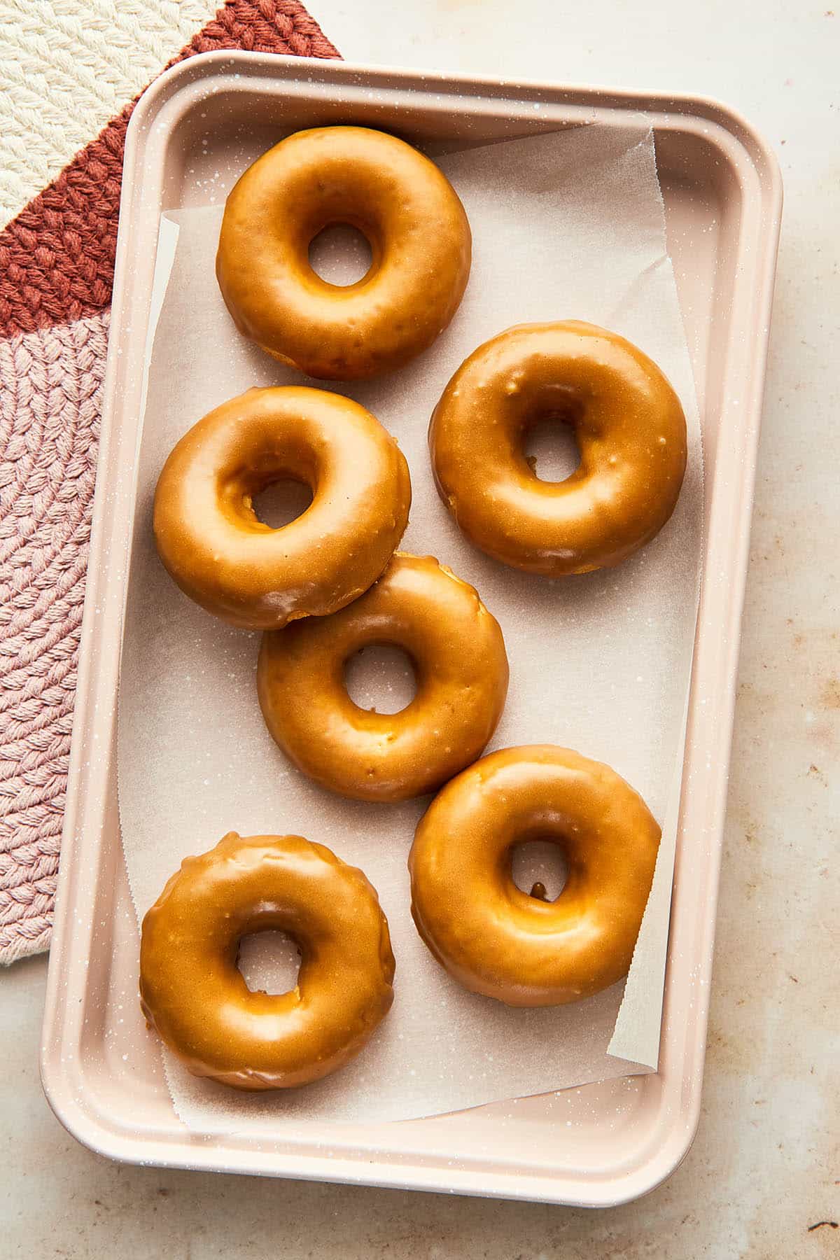 A tray filled with glazed donuts.