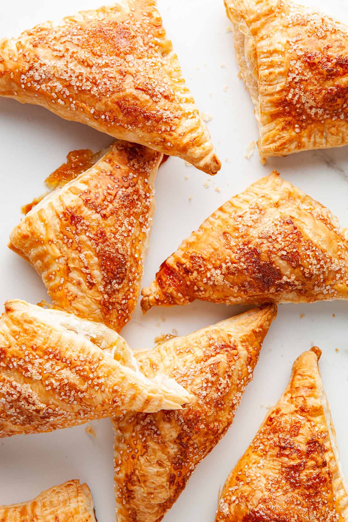 Several peach turnovers piled together on a light background.