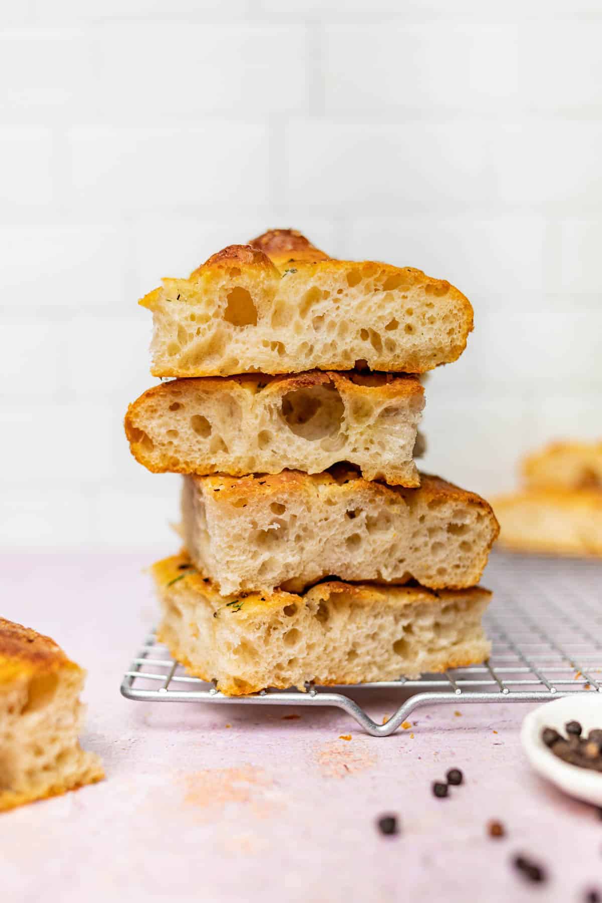 A stack of four slices of focaccia on a wire rack.