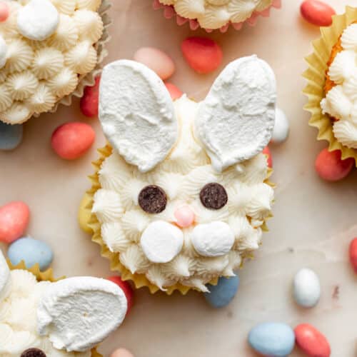 Easter bunny face cupcakes made from white frosting and marshmallow ears.