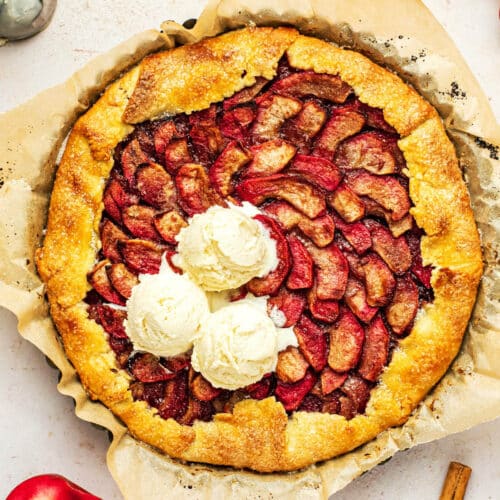 Galette filled with pink apples in a spiral and topped with vanilla ice cream.