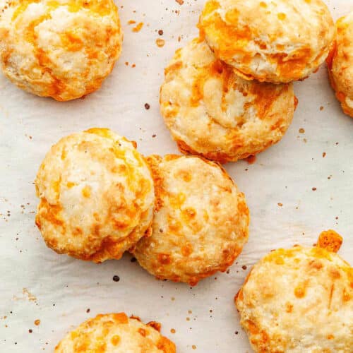 Cheese biscuits on parchment paper, top down view.