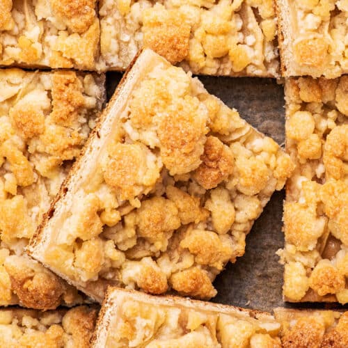 Close up of a German yeasted apple cake with streusel topping, cut into squares.
