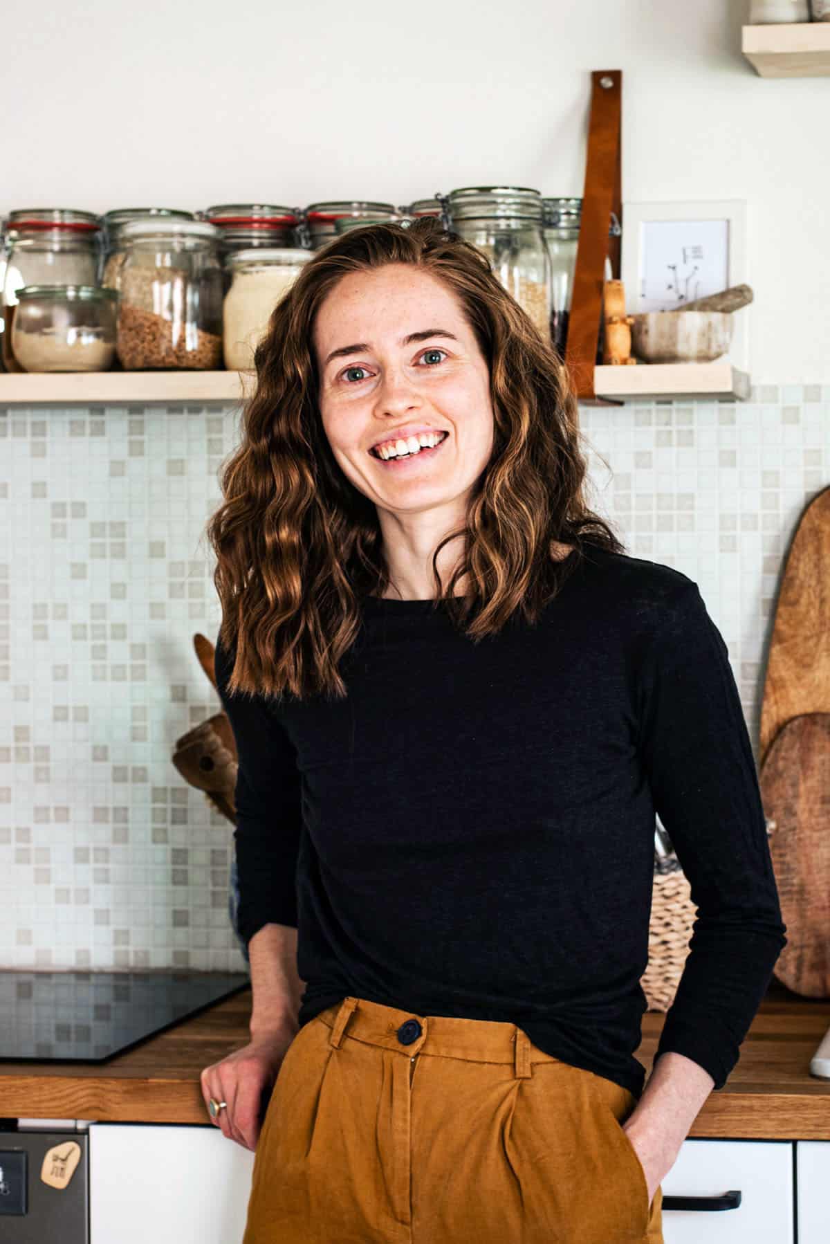 A smiling woman in a kitchen setting.