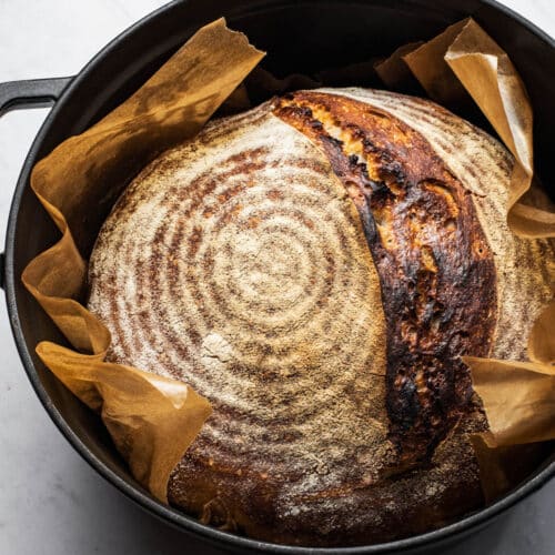 A loaf of sourdough bread in a Dutch oven.