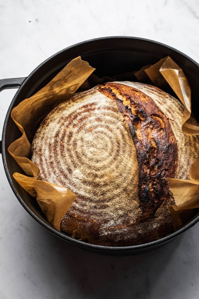 A loaf of sourdough bread in a Dutch oven.