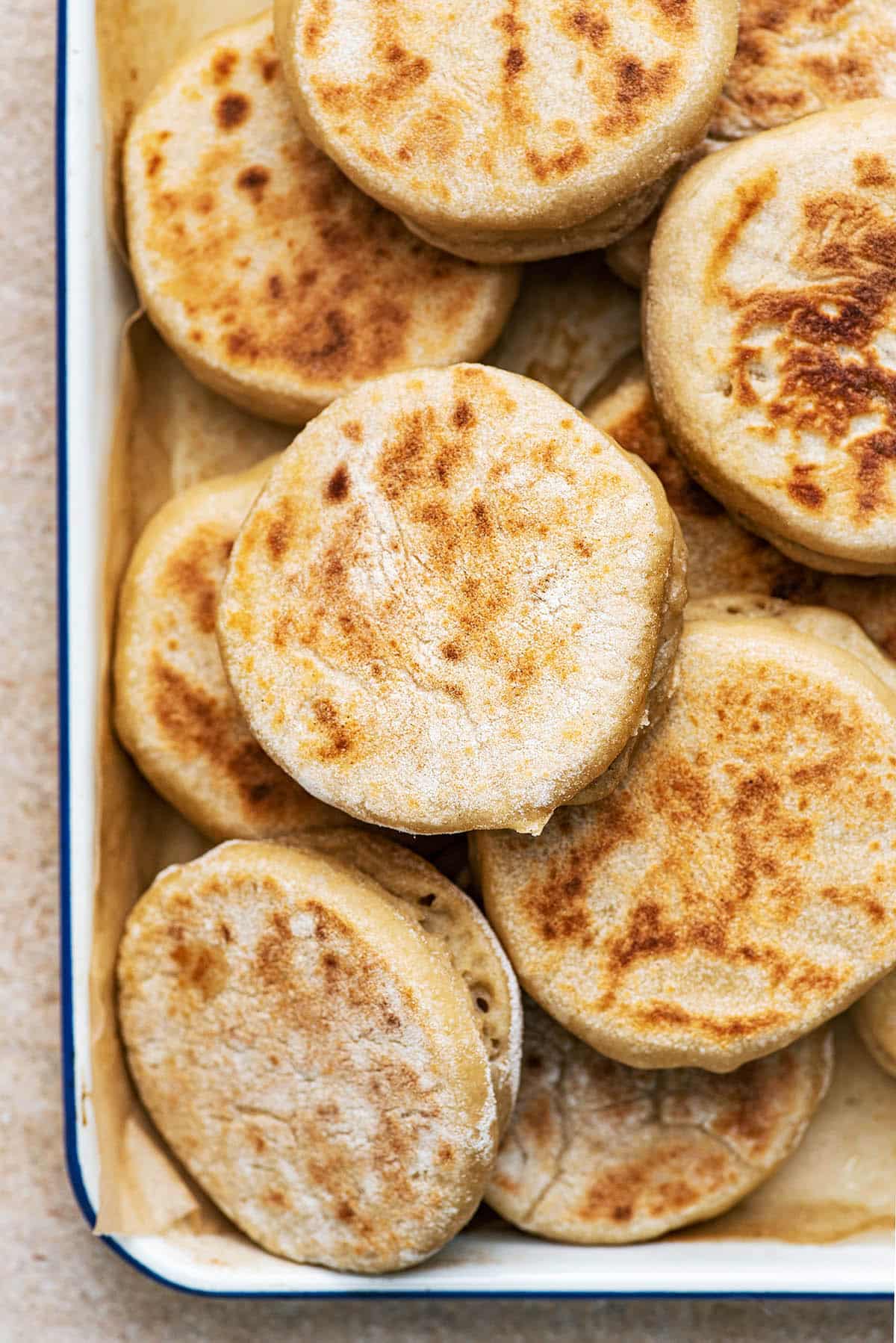 A tray full of english muffins, top down view.