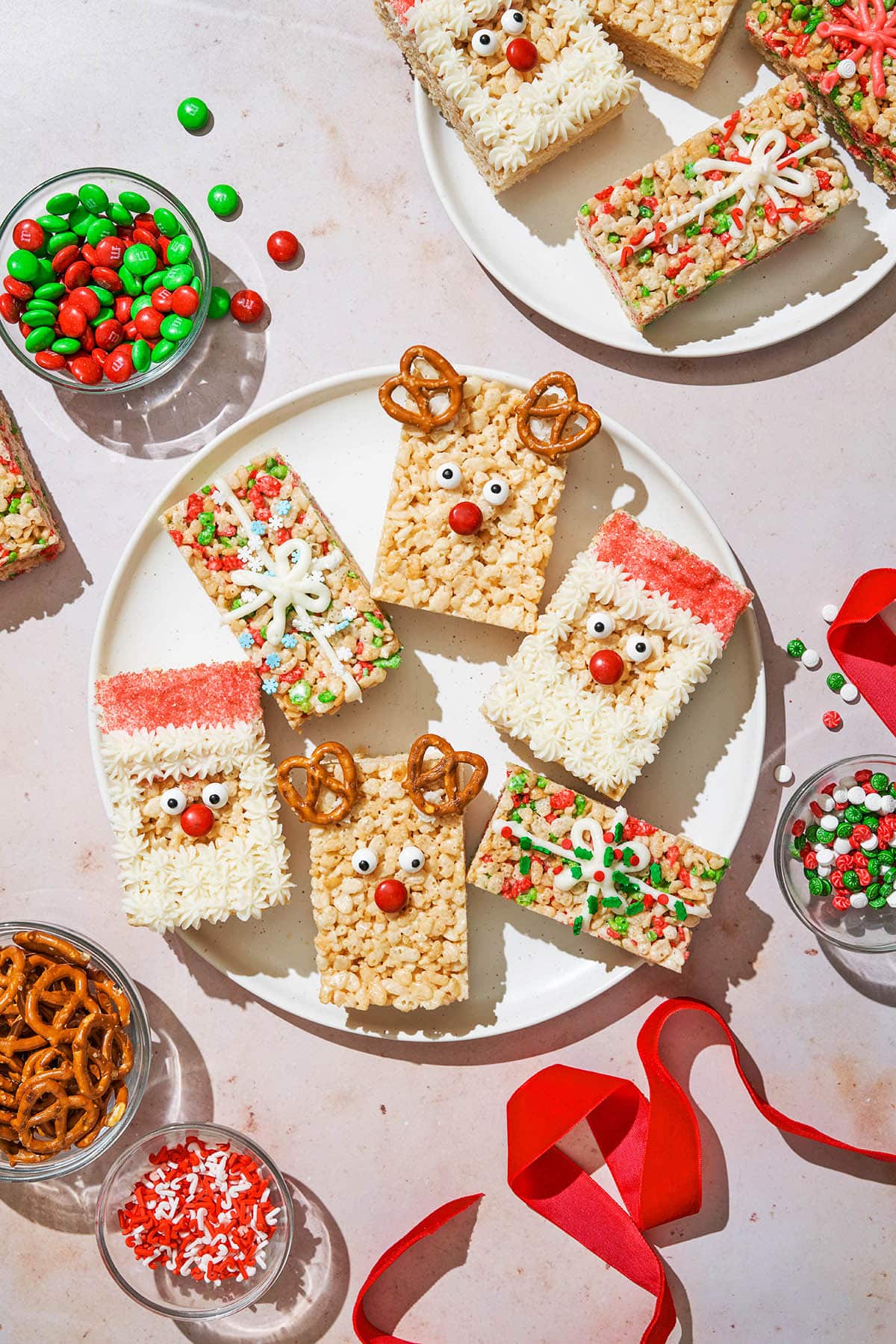 Several holiday decorated rice crisp bars with holiday decorations around.