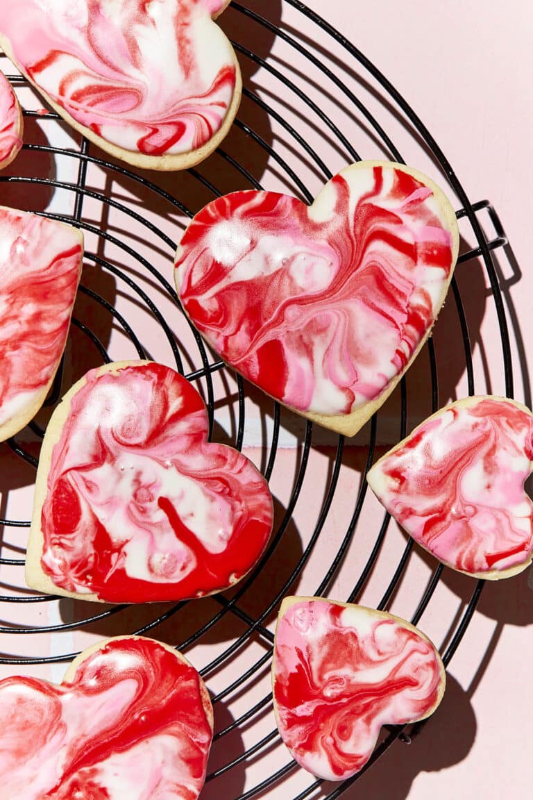 Several heart-shaped cookies on a wire rack.
