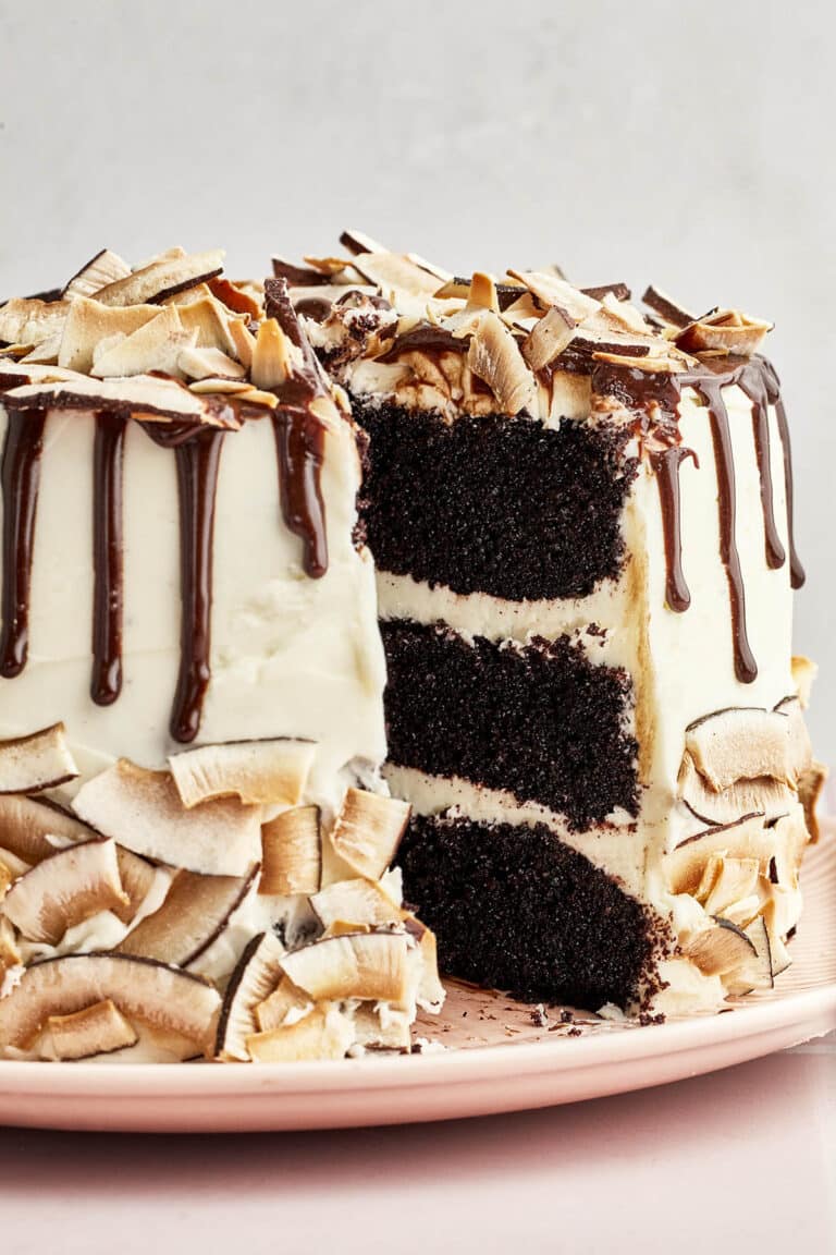 Layered chocolate cake with one slice removed to show interior.