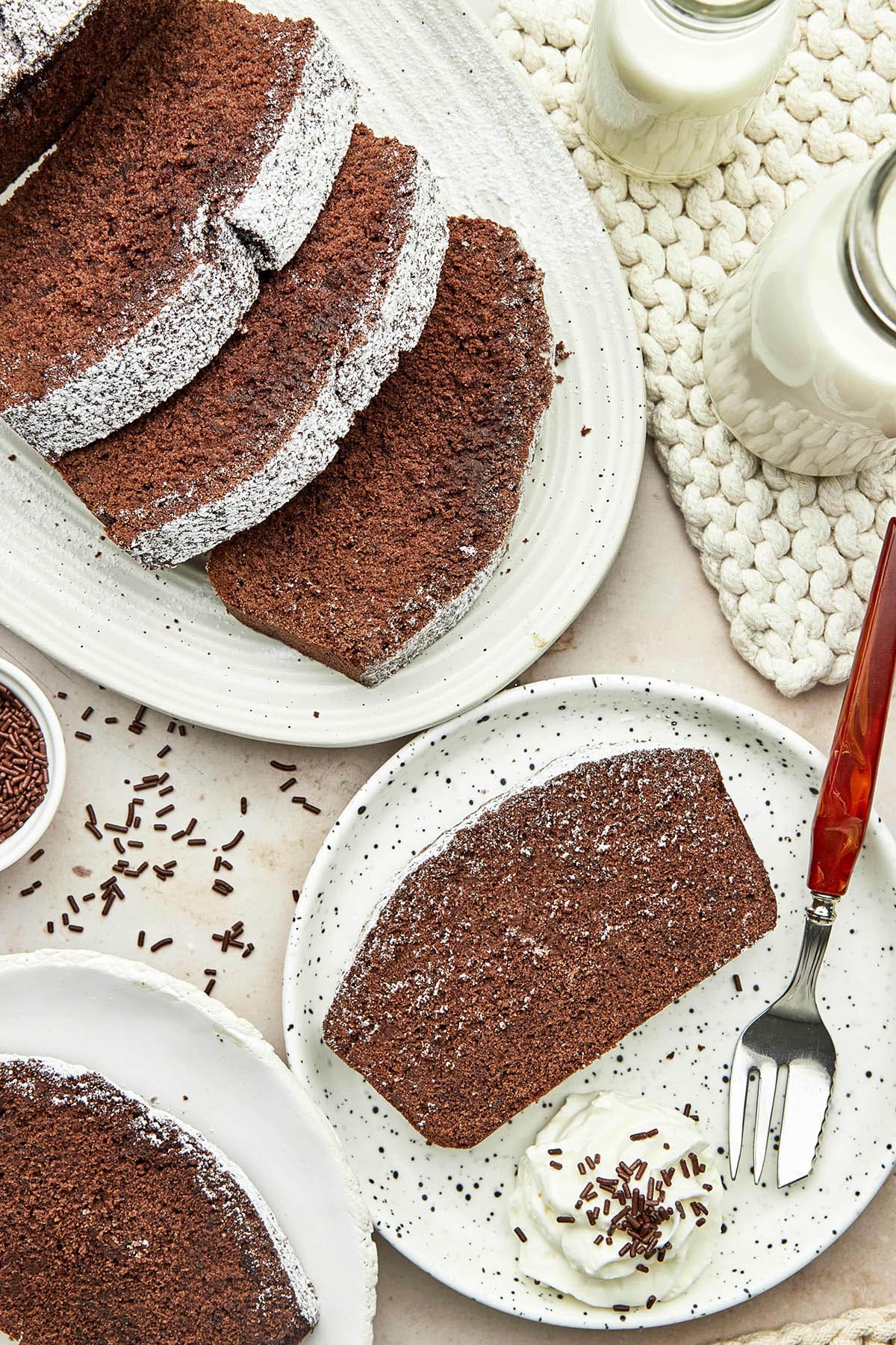 Several slices of chocolate pound cake on a serving platter and plates.