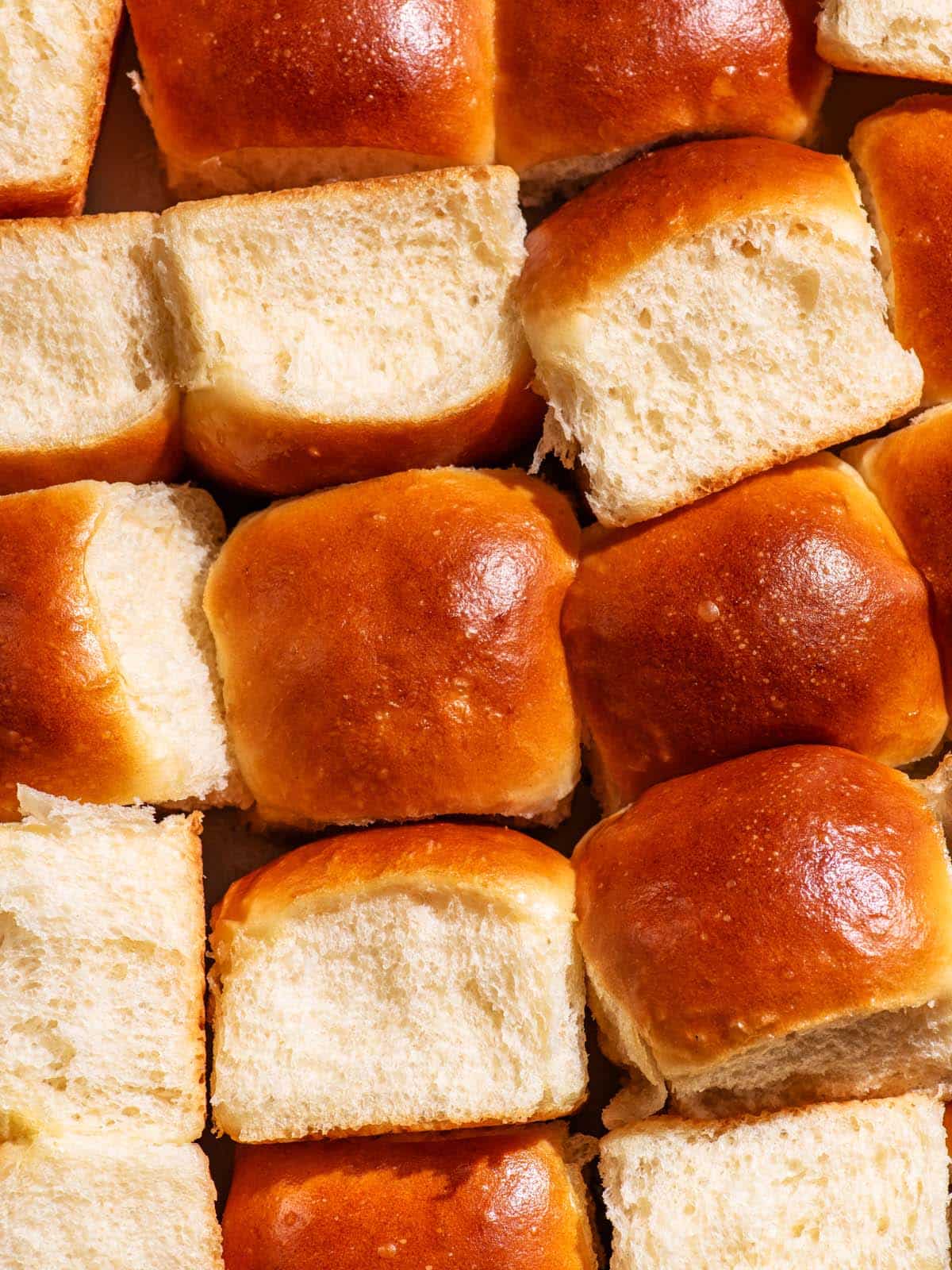 Several buns in the baking dish, turned on their sides, top-up, arranged unevenly.