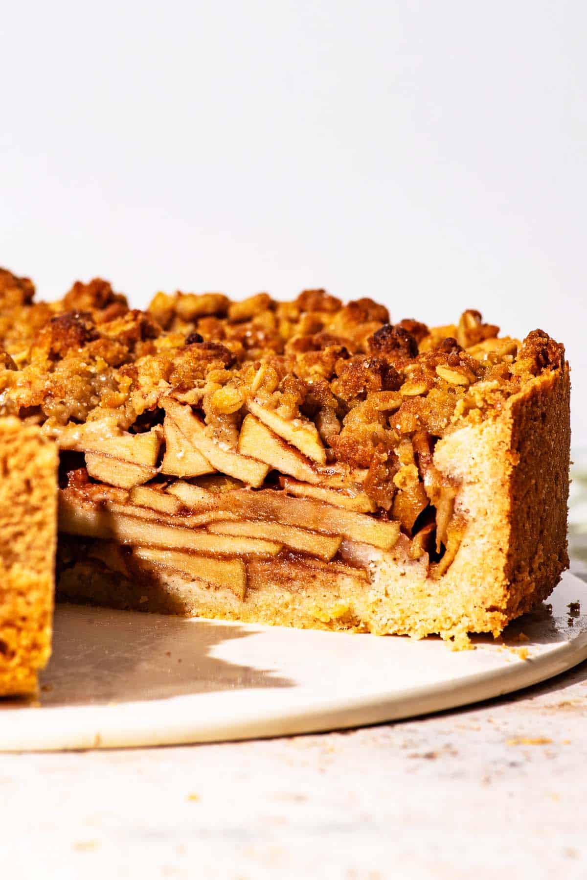 Tall apple tart with a slice removed.